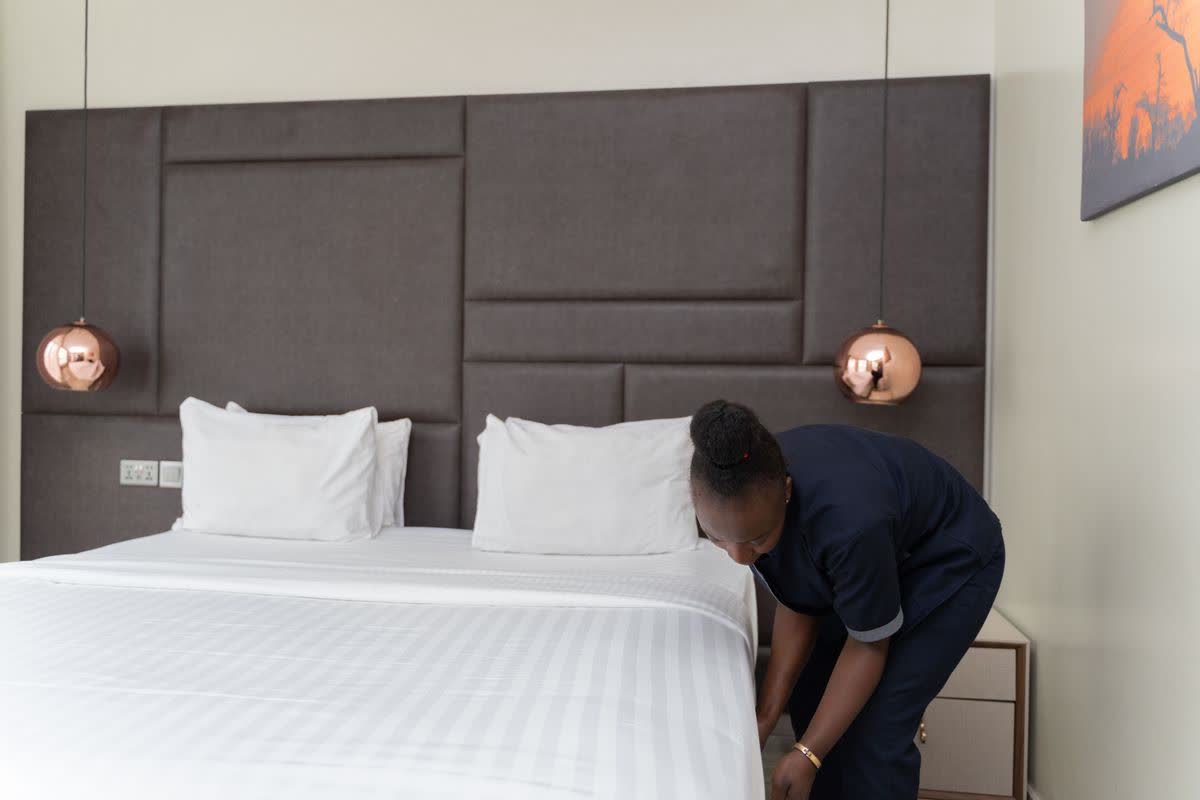 Housekeeper styling a hotel-quality bed