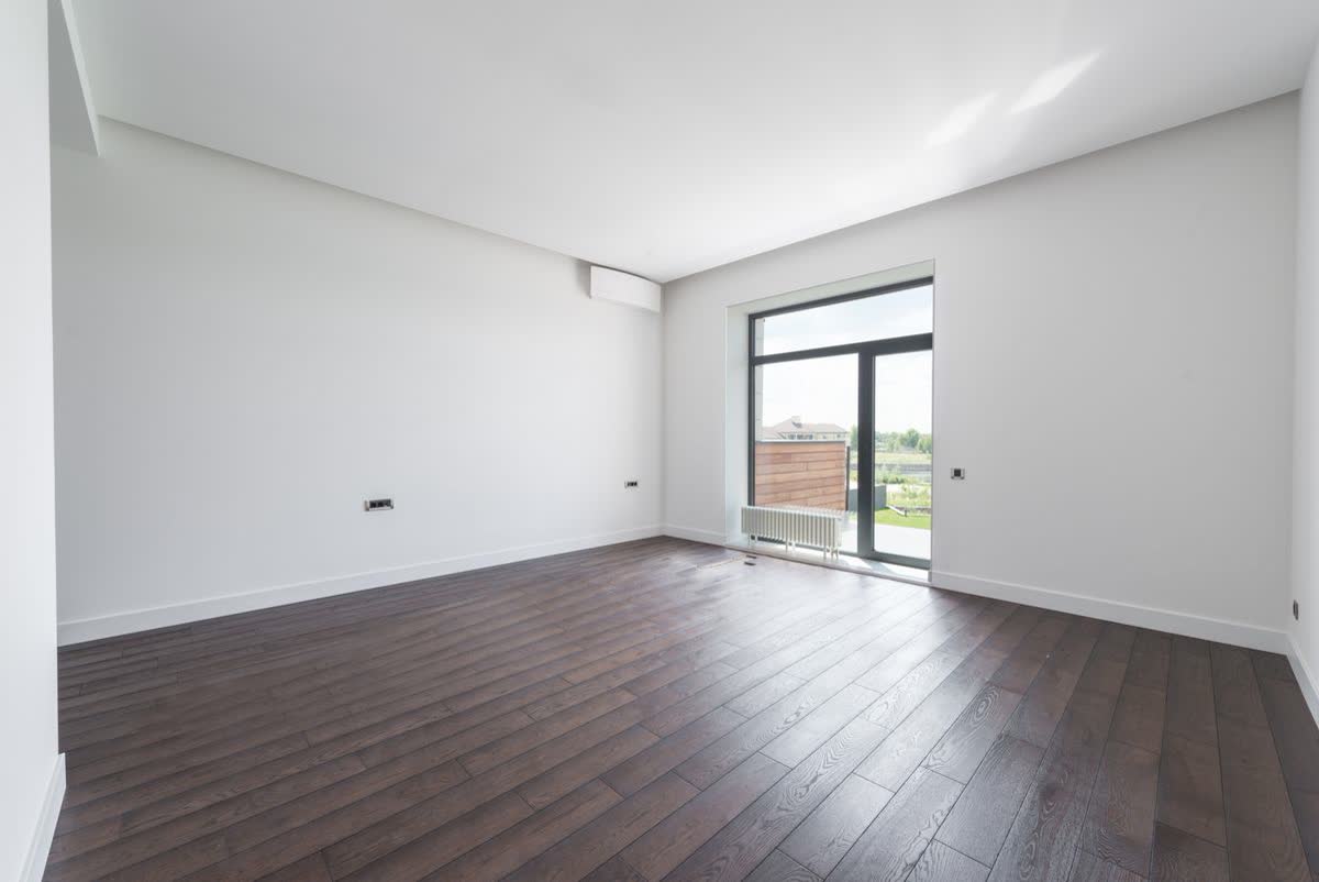 Spotless empty room with dark wood floors, ready for move-in